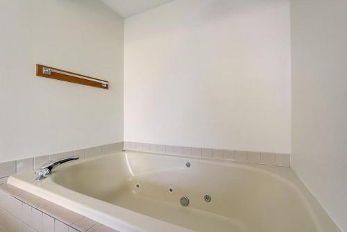a white bath tub in a white bathroom at Sunrise Suites - Lakefront - Location Location in Wisconsin Dells