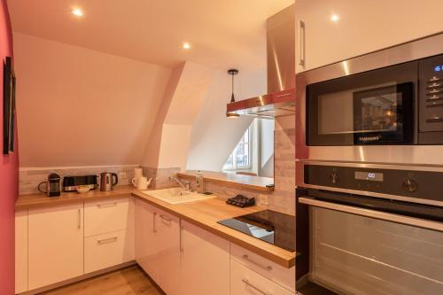 una cucina con lavandino e forno a microonde di Soft time - Luxury flat - Historic Centre Honfleur a Honfleur