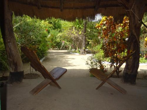 un par de sillas sentadas bajo una cabaña en Kansala Ta Toto, en Kafountine