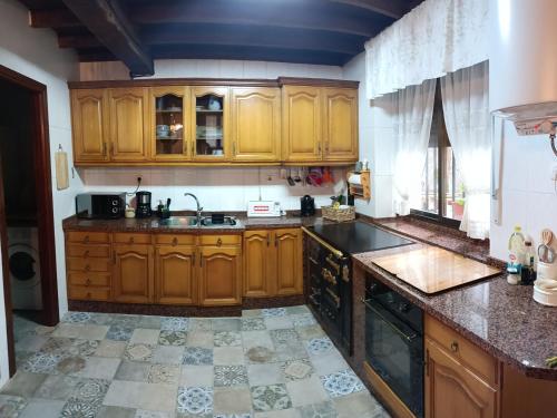 a kitchen with wooden cabinets and a sink at Casa Joglar in Beceña