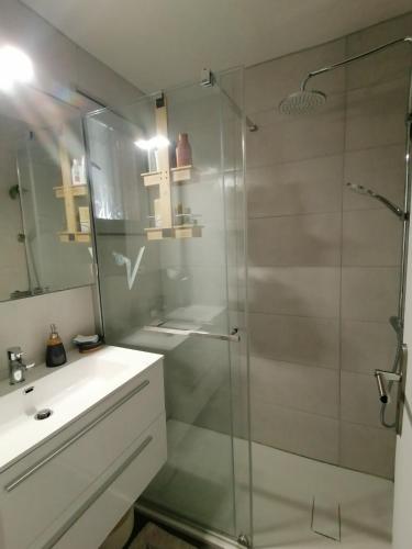 une salle de bain avec une douche en verre et un lavabo dans l'établissement LE SOLEIL D'OR, à Sainte-Maxime