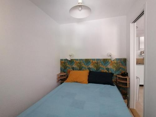 - une petite chambre avec un lit bleu dans l'établissement LE SOLEIL D'OR, à Sainte-Maxime