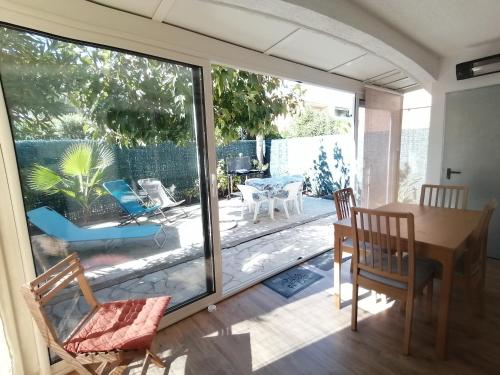 una sala da pranzo con porta scorrevole in vetro che si apre su un patio di LE SOLEIL D'OR a Sainte-Maxime