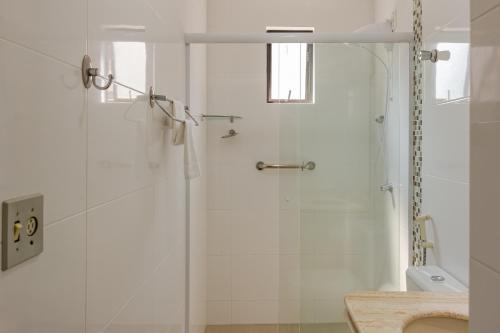 La salle de bains est pourvue d'une douche avec une porte en verre. dans l'établissement Apto 2 quartos na Rua 2950, Wifi e Garagem Grande P1232, à Balneário Camboriú