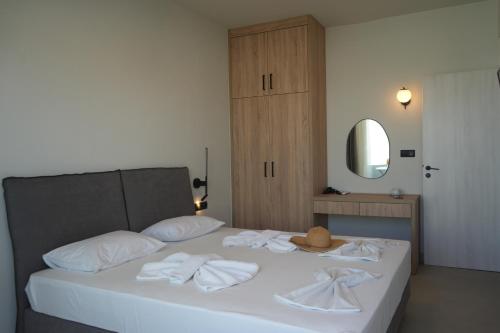 a bed with white towels and a hat on it at Hotel Kathrin Beach in Adelianos Kampos