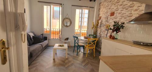 cocina y sala de estar con sofá y mesa en EN EL CORAZON DE GRANADA, en Granada