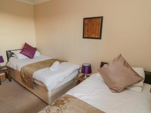 two beds in a small room with sidx sidx sidx sidx at Long Cart Cottage in Embleton