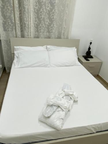 Una cama blanca con una toalla blanca. en Le bougainvillea 2, en Corbetta