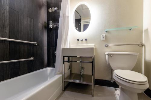 a bathroom with a toilet and a sink and a tub at Solita Soho Hotel in New York