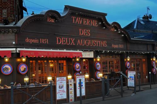 a restaurant with signs on the front of a building at La Taverne des Deux Augustins in Étretat