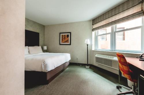 sypialnia z łóżkiem, biurkiem i oknem w obiekcie Solita Soho Hotel w Nowym Jorku