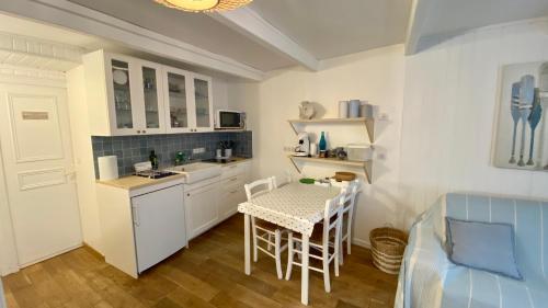 une petite cuisine avec une table et une table et des chaises dans l'établissement La perle des Bains, à Trouville-sur-Mer