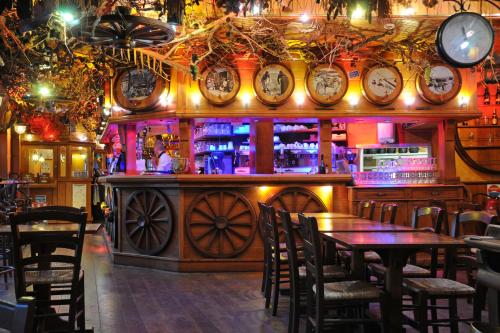 a bar with tables and clocks on the wall at La Taverne des Deux Augustins in Étretat