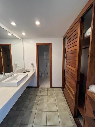 a bathroom with two sinks and a large mirror at Novotel Salvador Rio Vermelho in Salvador