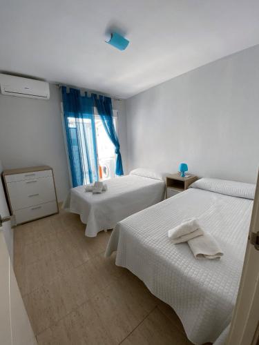 ロケタス・デ・マルにあるApartamento Aguadulce Playaのベッド2台と窓が備わるホテルルームです。