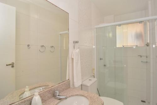 uma casa de banho com um lavatório, um chuveiro e um WC. em Vista Mar na quadra do Atlântico Shopping P1287 em Balneário Camboriú
