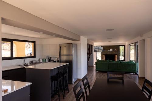 a kitchen and living room with a green couch at El Mirador in Esquel