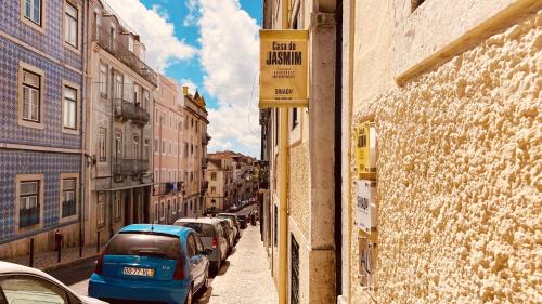 a narrow street with cars parked on the side of a building at Casa do Jasmim by Shiadu in Lisbon