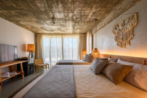 a bedroom with two beds and a flat screen tv at Ambar Hotel in Punta del Este