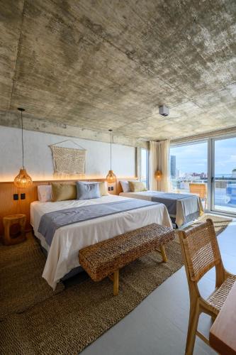 a large bedroom with two beds and a large window at Ambar Hotel in Punta del Este