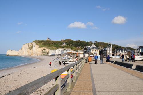 a group of people walking on the beach at La Taverne des Deux Augustins in Étretat