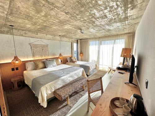 a bedroom with two beds and a television in it at Ambar Hotel in Punta del Este