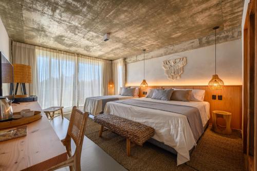 a bedroom with two beds and a table and a desk at Ambar Hotel in Punta del Este