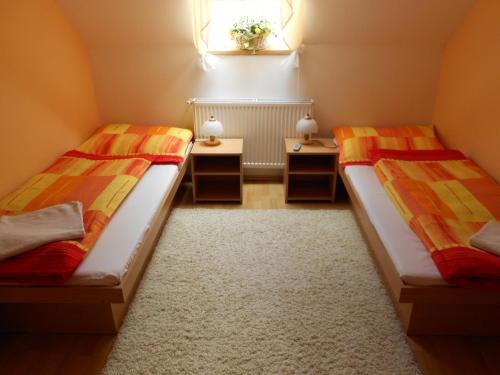 two beds in a room with two tables at Penzion Rosnicka Liesek in Trstená