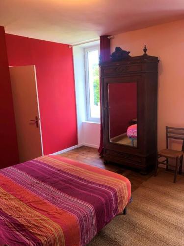 a bedroom with a bed and a mirror and a window at L'hôte des voyageurs en pays limousin 2 in Lacelle