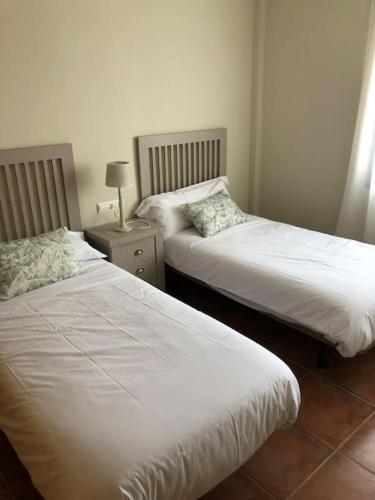 a bedroom with two beds and a table with a lamp at Casa Picual, Mancha Real, Jaén in Mancha Real