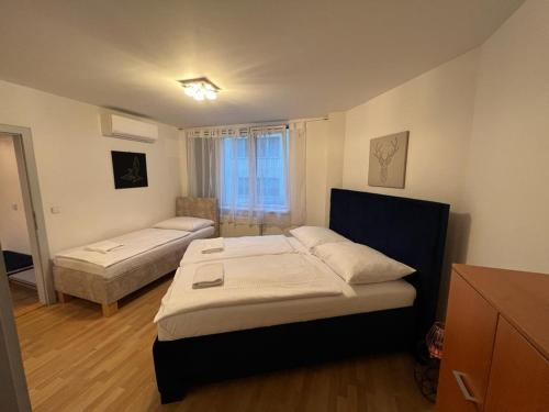 um pequeno quarto com 2 camas e uma janela em Iren Apartment Bratislava em Bratislava
