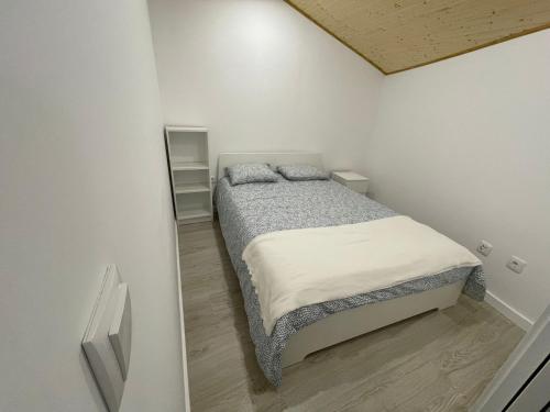 a small white bedroom with a bed in it at Casinha da fonte in Arcos de Valdevez