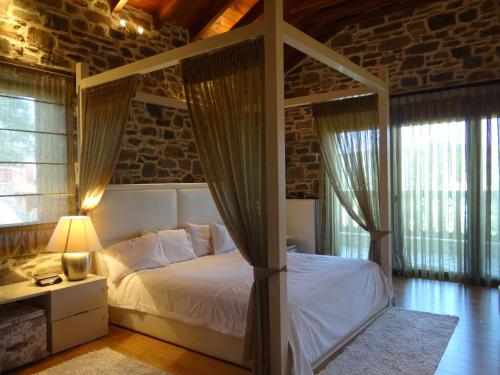 een slaapkamer met een hemelbed bij Villa Ria 