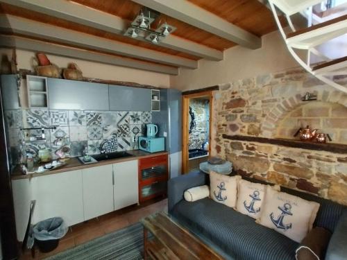 ein Wohnzimmer mit einem Sofa und einer Steinmauer in der Unterkunft MASTIXI Colors in Chios