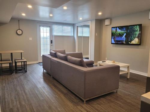 a living room with a couch and a tv at QUIET Appartment near Montreal CITQ 3O9764 in Longueuil