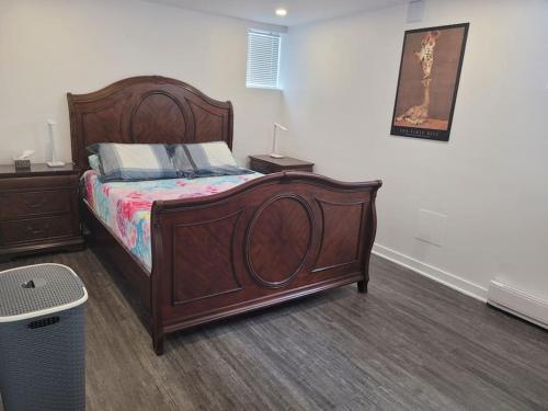 ein Schlafzimmer mit einem großen Holzbett in einem Zimmer in der Unterkunft QUIET Appartment near Montreal CITQ 3O9764 in Longueuil