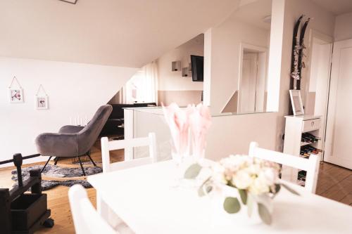 un salon avec une table et des chaises blanches dans l'établissement Pfälzer Herzel, à Neustadt an der Weinstraße