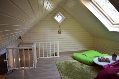 a room with a green bed in a attic at Nice holiday home in Hokensas nature reserve in Tidaholm