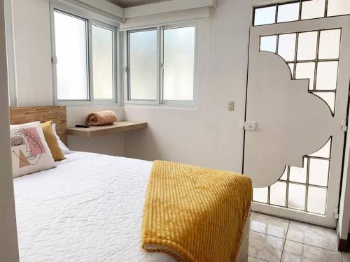 a bedroom with a bed with a yellow blanket on it at Detailed and Modern Apartment D in Guatemala