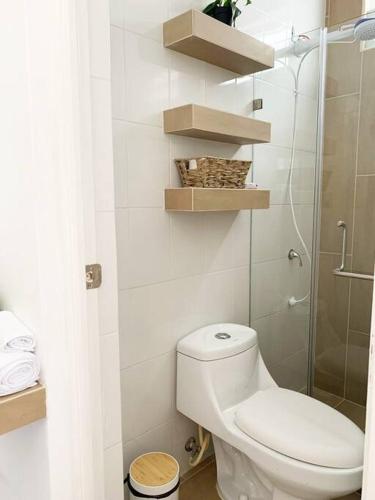 a bathroom with a toilet and a glass shower at Detailed and Modern Apartment D in Guatemala