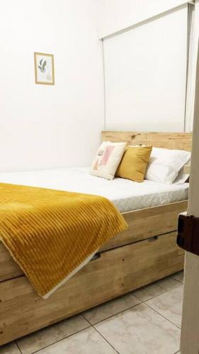 a bedroom with a wooden bed with pillows on it at Detailed and Modern Apartment D in Guatemala