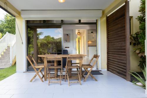 une salle à manger avec une table et des chaises sur une terrasse dans l'établissement Eirene - Trois Ilets, à Les Trois-Îlets