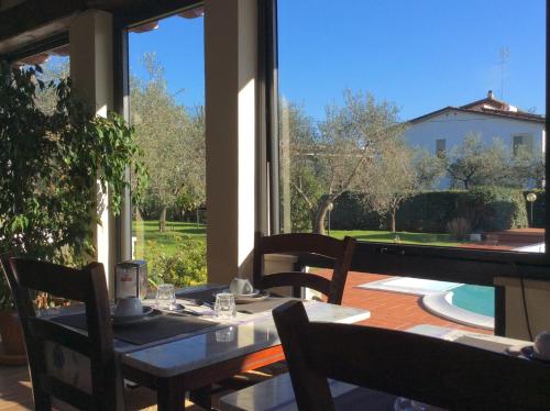 a patio with a table and chairs and a large window at B&B Il Portico in Sarzana