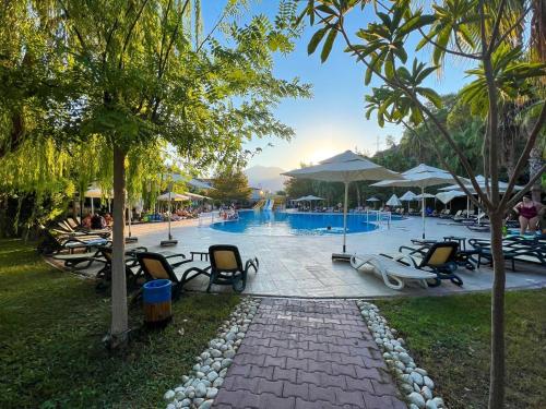 a resort with a pool with chairs and umbrellas at Golden Sunset Hotel&spa in Kemer