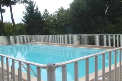 een zwembad met een hek eromheen bij Villa patio classée proche océan in Capbreton