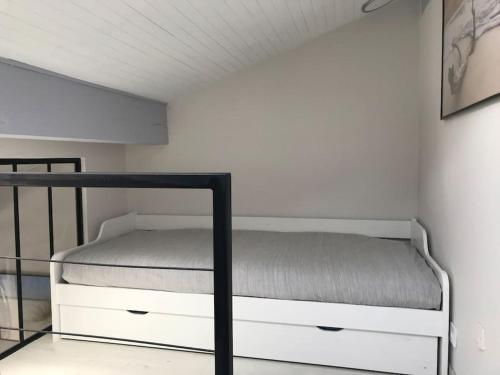 een bed in een kamer met een witte muur bij Villa patio classée proche océan in Capbreton