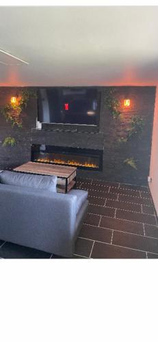 ein Wohnzimmer mit Couch und Kamin in der Unterkunft Charmant logement avec cheminée,cour,wifi,Netflix in Blanzy