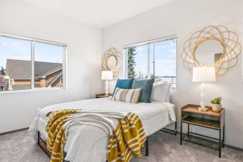 a white bedroom with a bed and two windows at Brand New 2 Bd 2 Bth Near DT and Perry District in Spokane