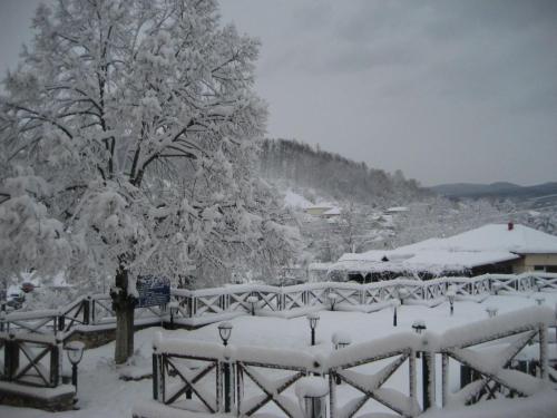 a snow covered yard with a fence and a tree at Villa Ria in Flámbouron
