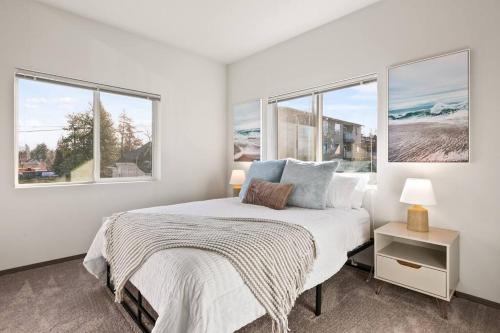 een witte slaapkamer met een bed en 2 ramen bij New 2 Bed 2 Bath Near Perry Dist and DT in Spokane
